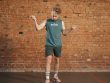 Caucasian man engaging in a jump rope workout in an indoor setting with a brick wall background.